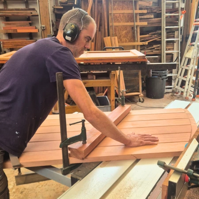 menuisier travaillant sur taille de la porte en moabi