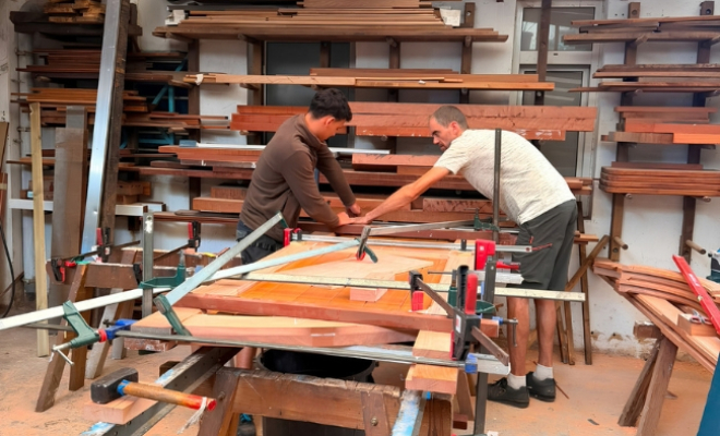 menuisier et ouvrier travaillant sur le collage de la porte en moabi