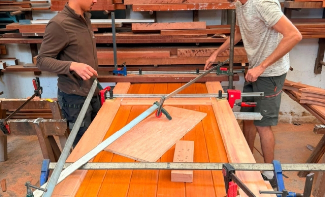 menuisier et ouvrier travaillant sur le collage de la porte en moabi